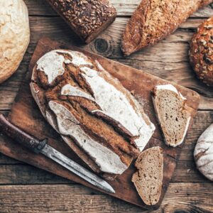 Delicious fresh bread on wooden background